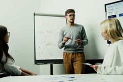 Adults discussing financial charts during a teamwork session.