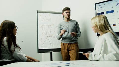 Adults discussing financial charts during a teamwork session.