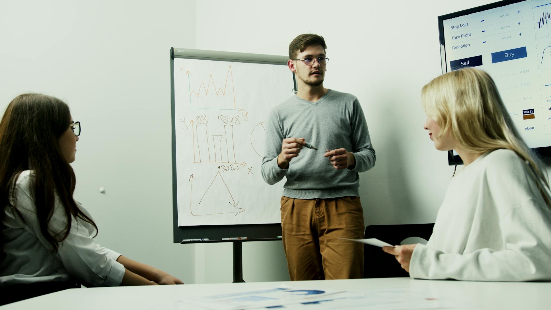 Adults discussing financial charts during a teamwork session.