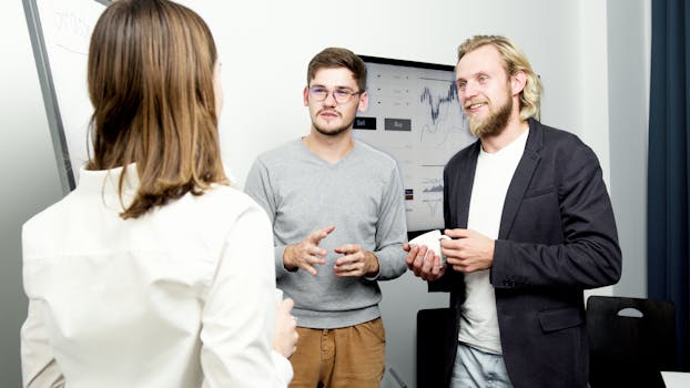 Team of professionals engaging in a lively office discussion about financial data.