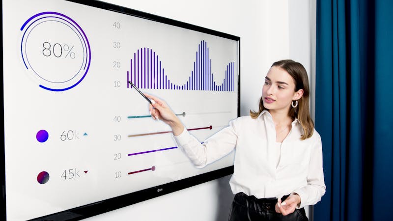 Businesswoman presenting data on a large digital screen