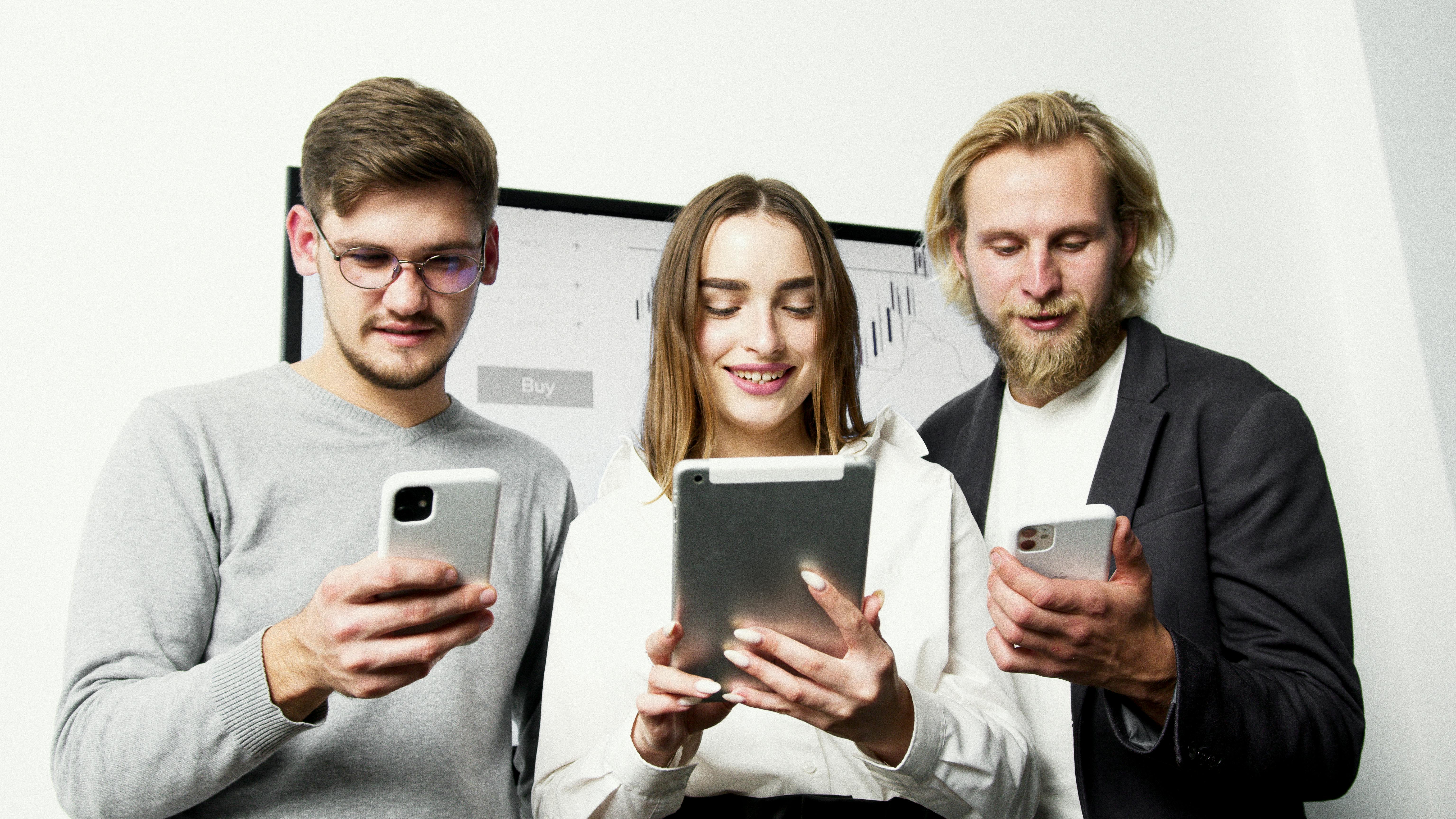 man in gray sweater holding silver iphone