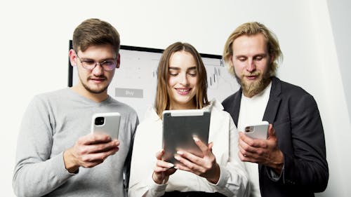 Man in Gray Sweater Holding Silver Iphone 6 Beside Woman in Gray Long Sleeve Shirt