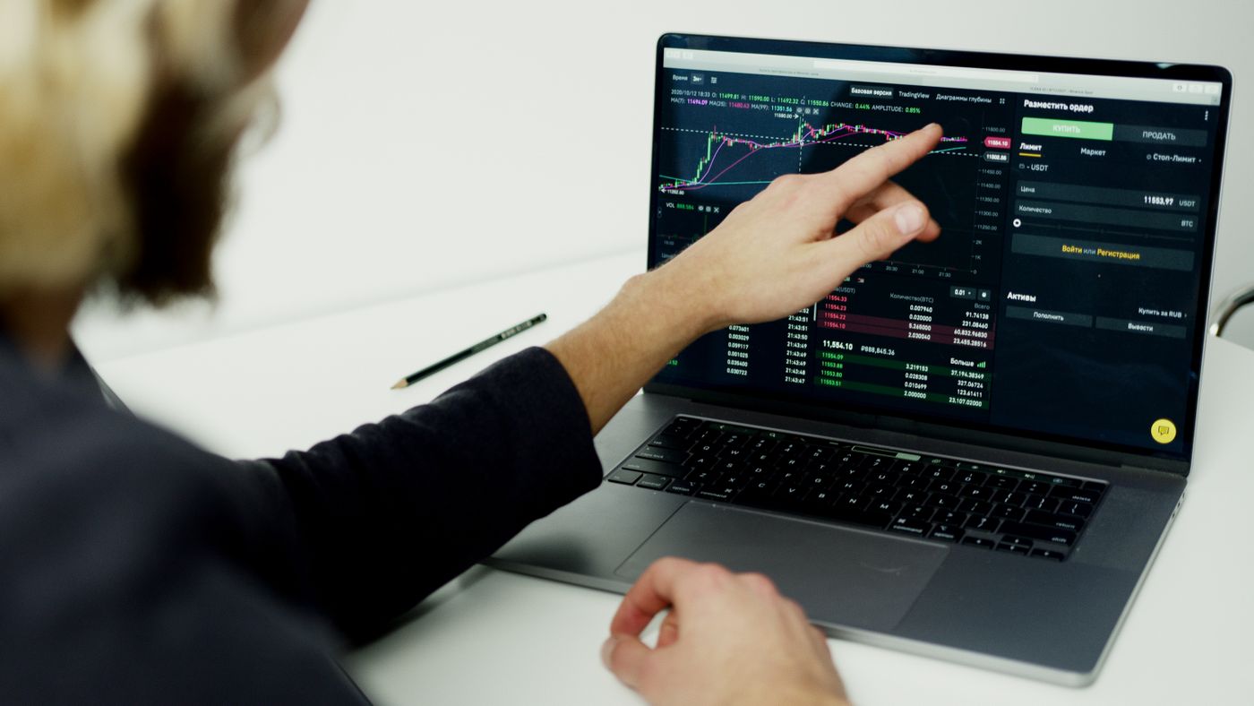 Trader studying stock market graphs to assess historical drawdown and strategy risk