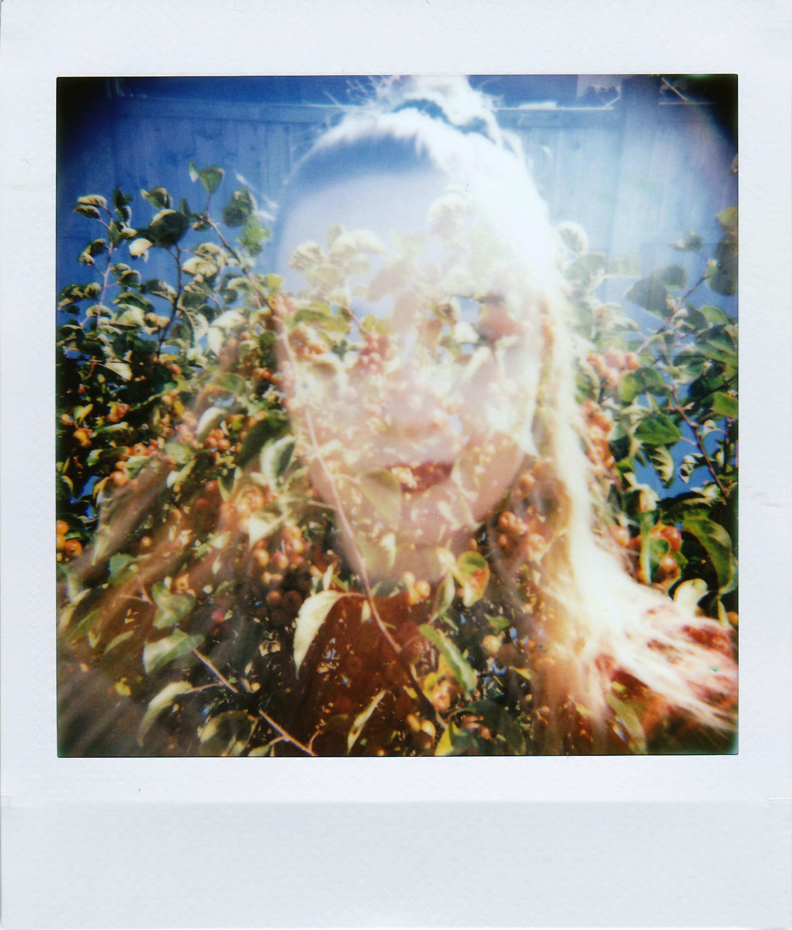 A creative double exposure portrait merges a woman's face with vibrant foliage.