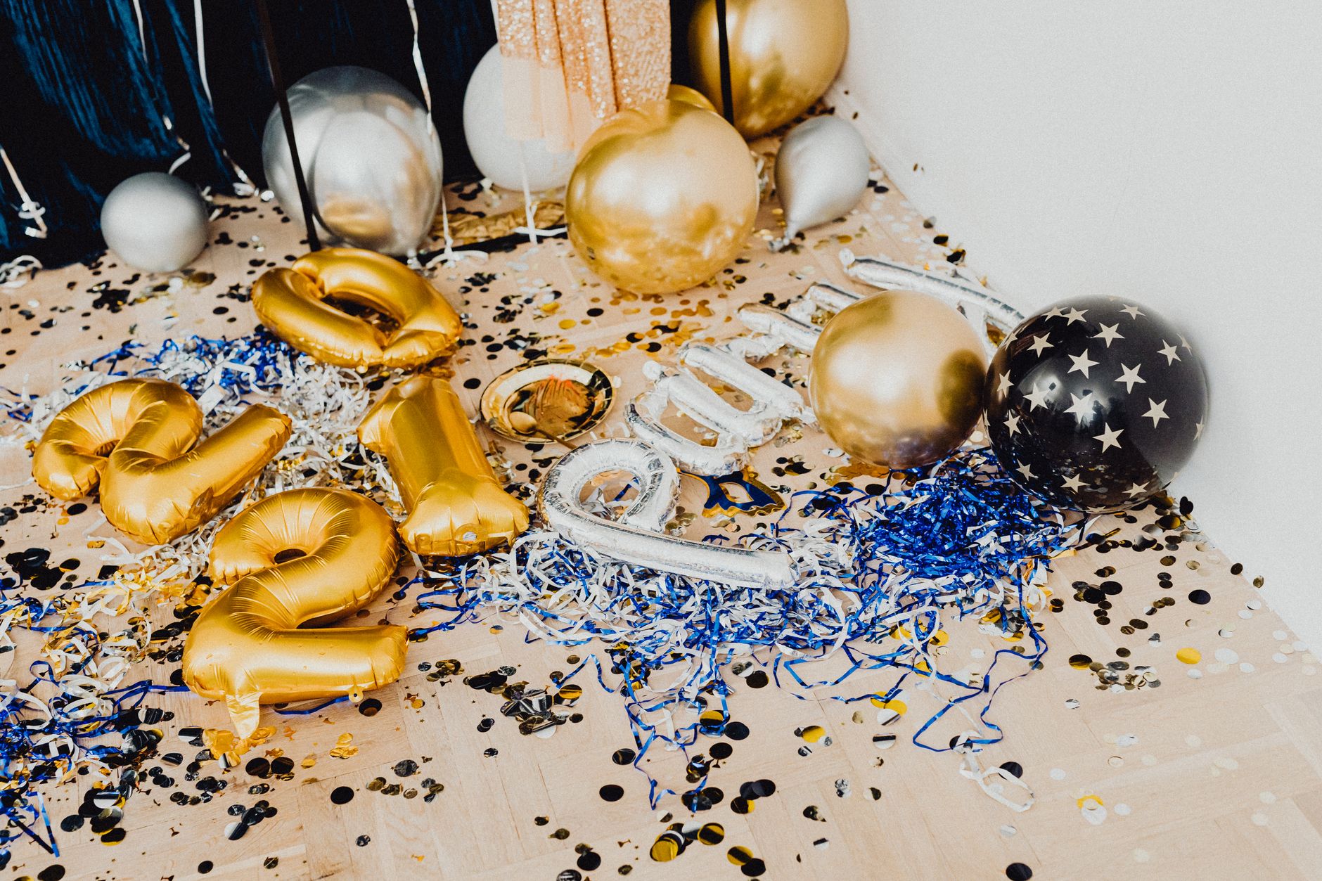 Colorful balloons and confetti scattered on the floor, perfect for a festive New Year's celebration.