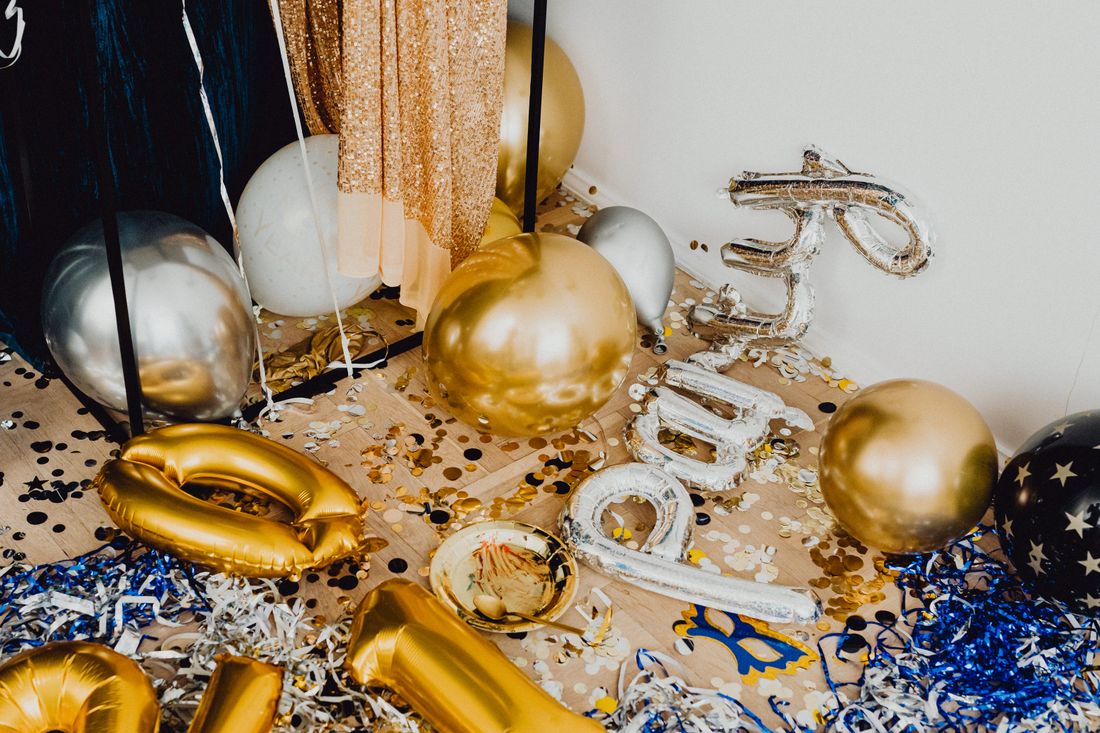 Festive party table with gold and silver balloons and confetti
