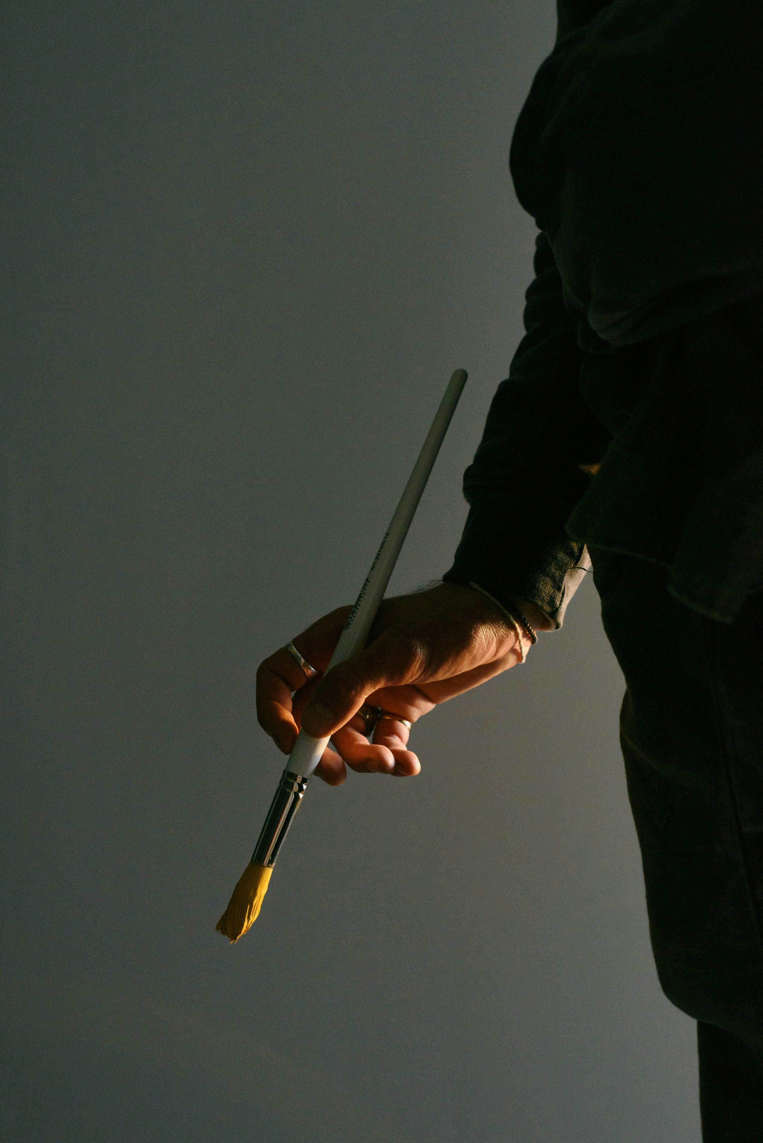 crop artist with paintbrush in studio