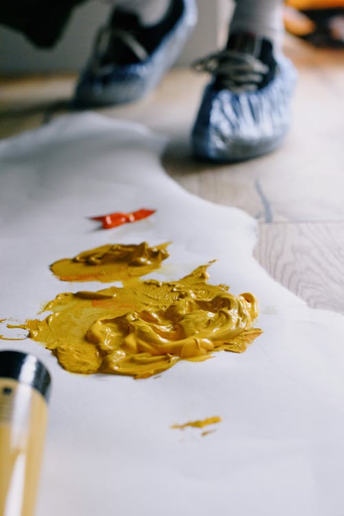 Free Yellow paint on paper sheet on floor Stock Photo