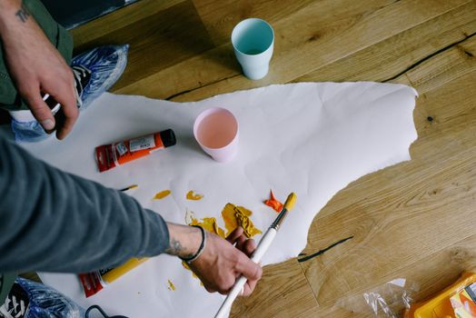 Crop faceless artist sopping paintbrush in paint on paper snatch