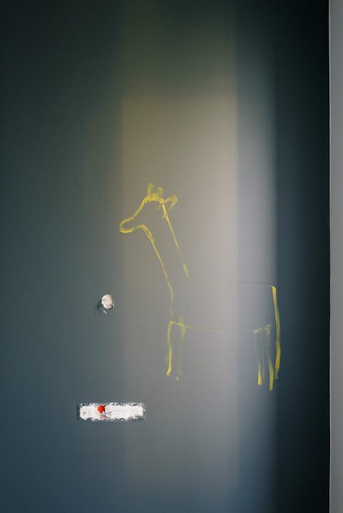Dark wall with uncompleted drawn yellow animal silhouette in new apartment during renovation