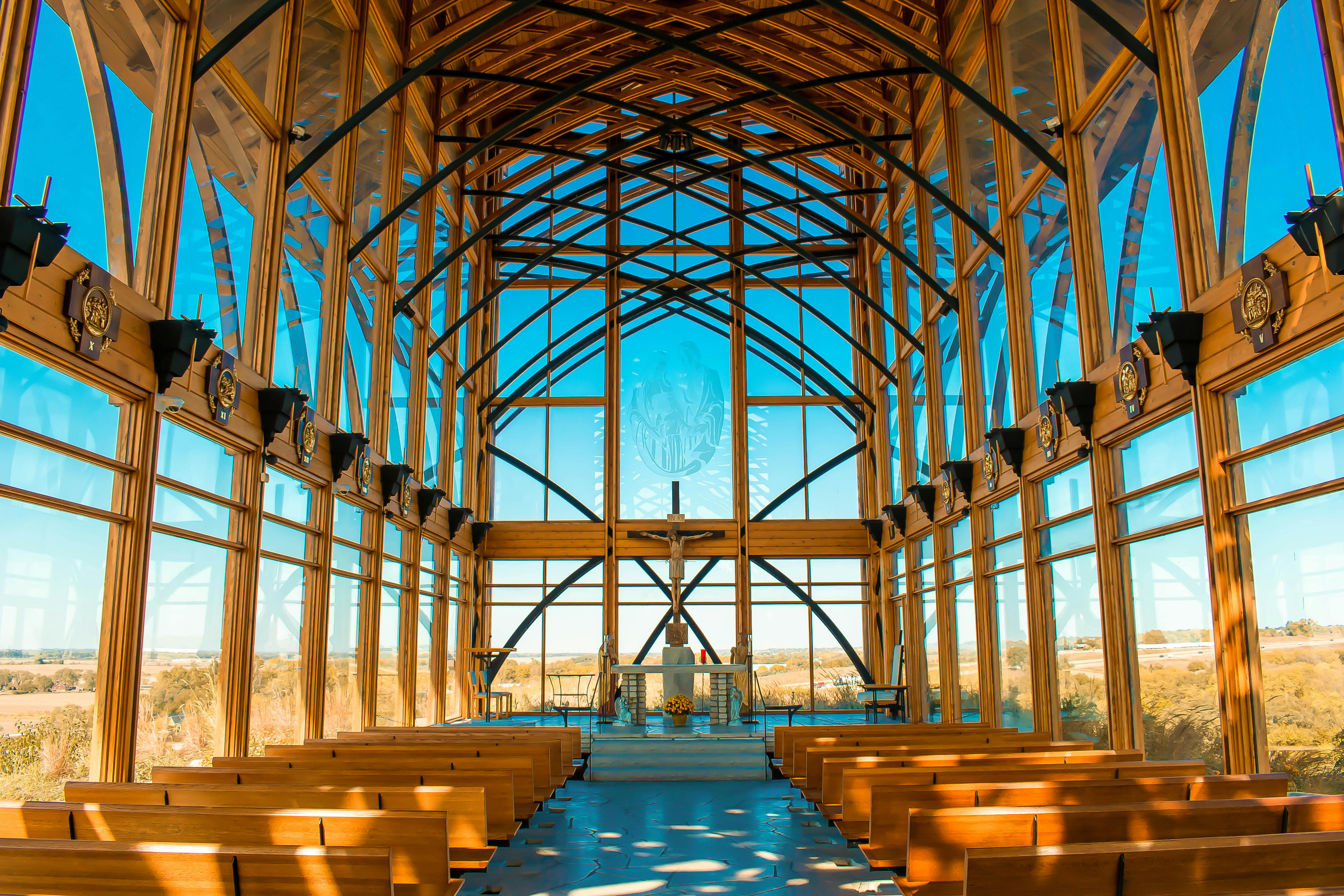 Funeral home chapel with modern wooden pews featuring padded arm rests - funeral home furnishings