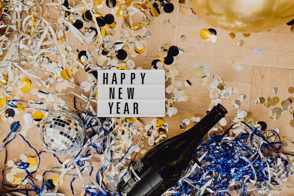 シャンパン、コンフェッティ、ライティングボックスメッセージを伴う新年の祝いの上からのビュー。