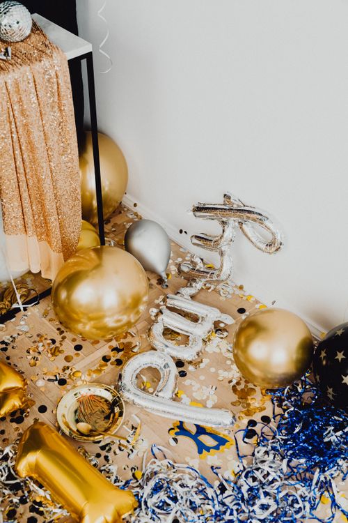New year's eve decor ideas with black and gold balloons and confetti