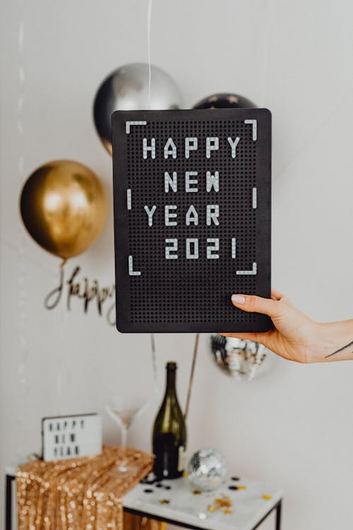 Free Person Holding A Happy New Year Text On A Black Board Stock Photo