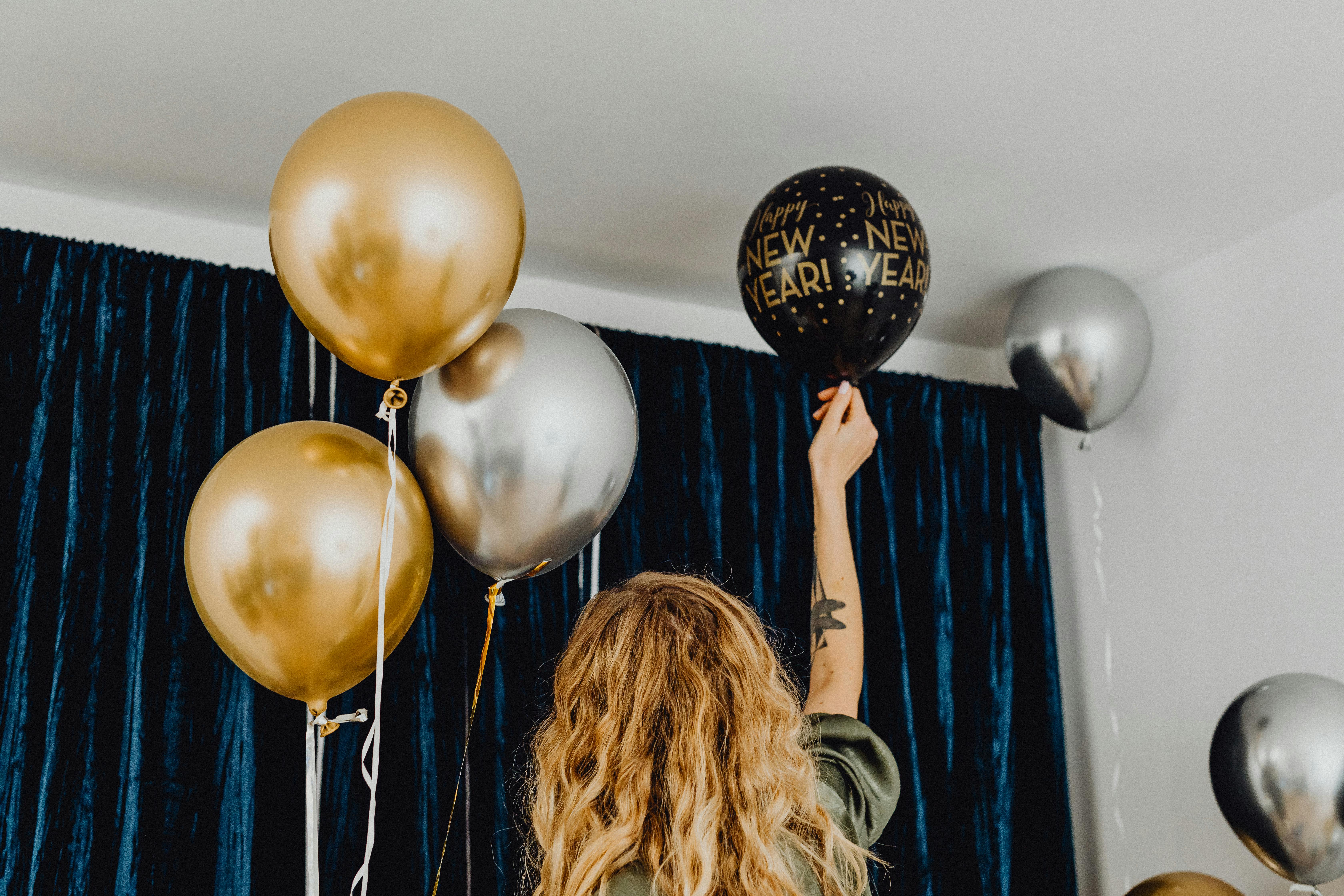 woman holding a balloon with helium and preparing the room for a party