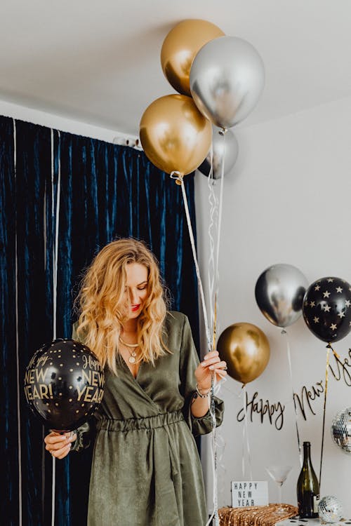 Free Woman in a Dress Holding a Bunch of Balloons  Stock Photo
