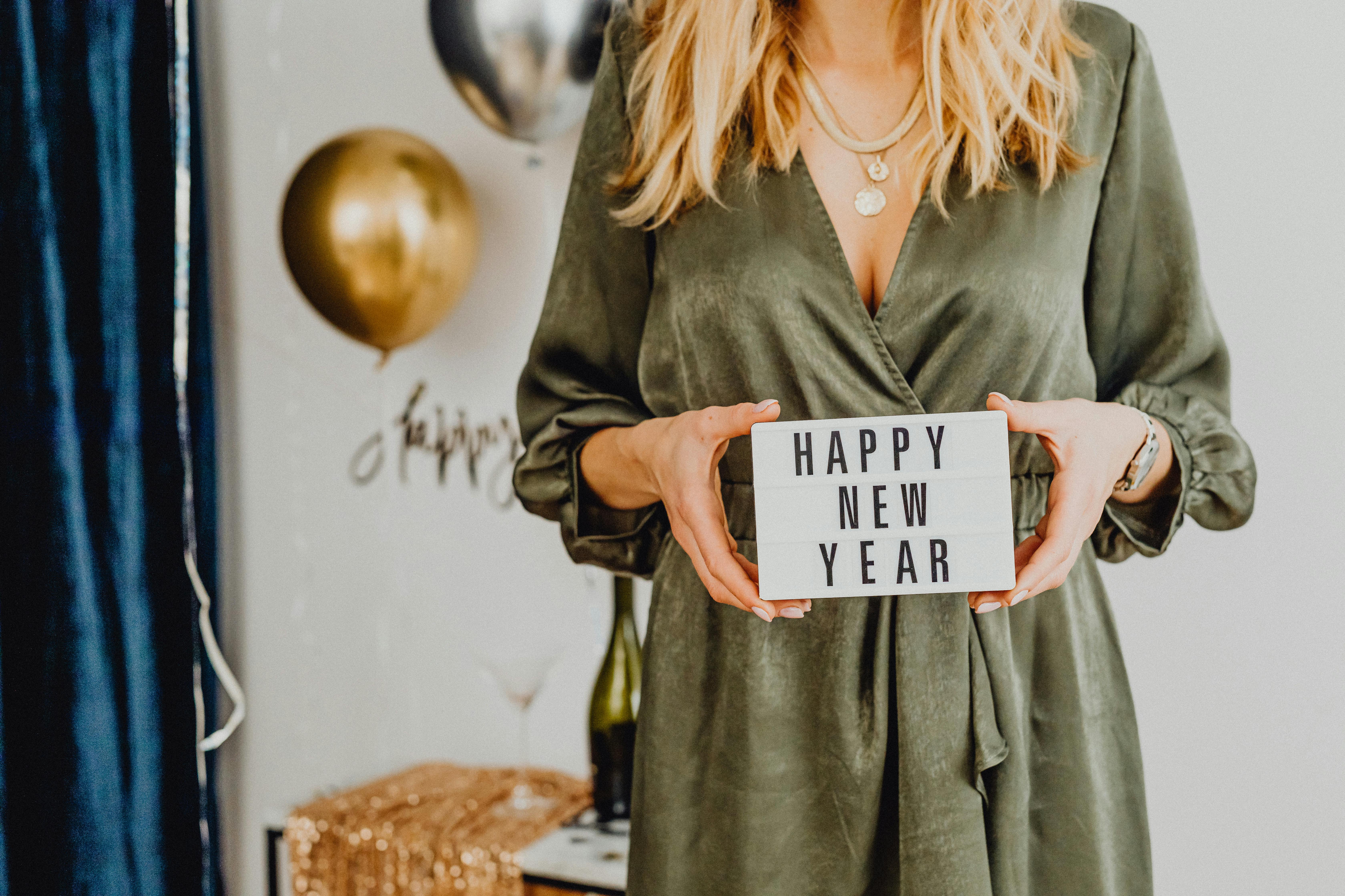 woman holding white card with happy new year text