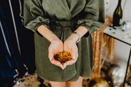 手持金色五彩纸屑的女子，象征着派对的优雅氛围