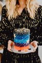Blonde Person Carrying a Colorful Cake