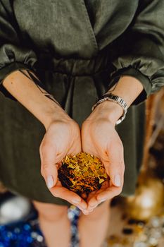 女人双手轻捧金色五彩纸屑，象征着庆祝与欢乐
