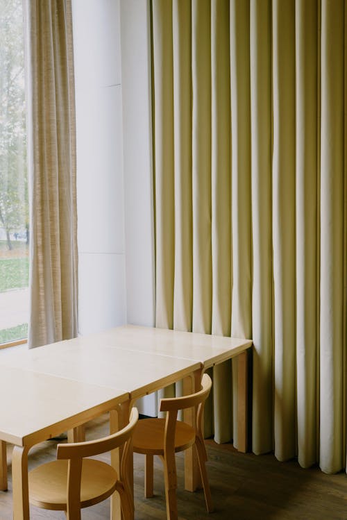 Table with chairs and curtains near window