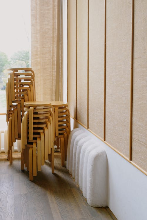 Free Wooden chairs in stack in corner of room Stock Photo