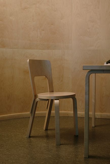 Interior of room with wooden furniture including chair and table in minimalistic apartment