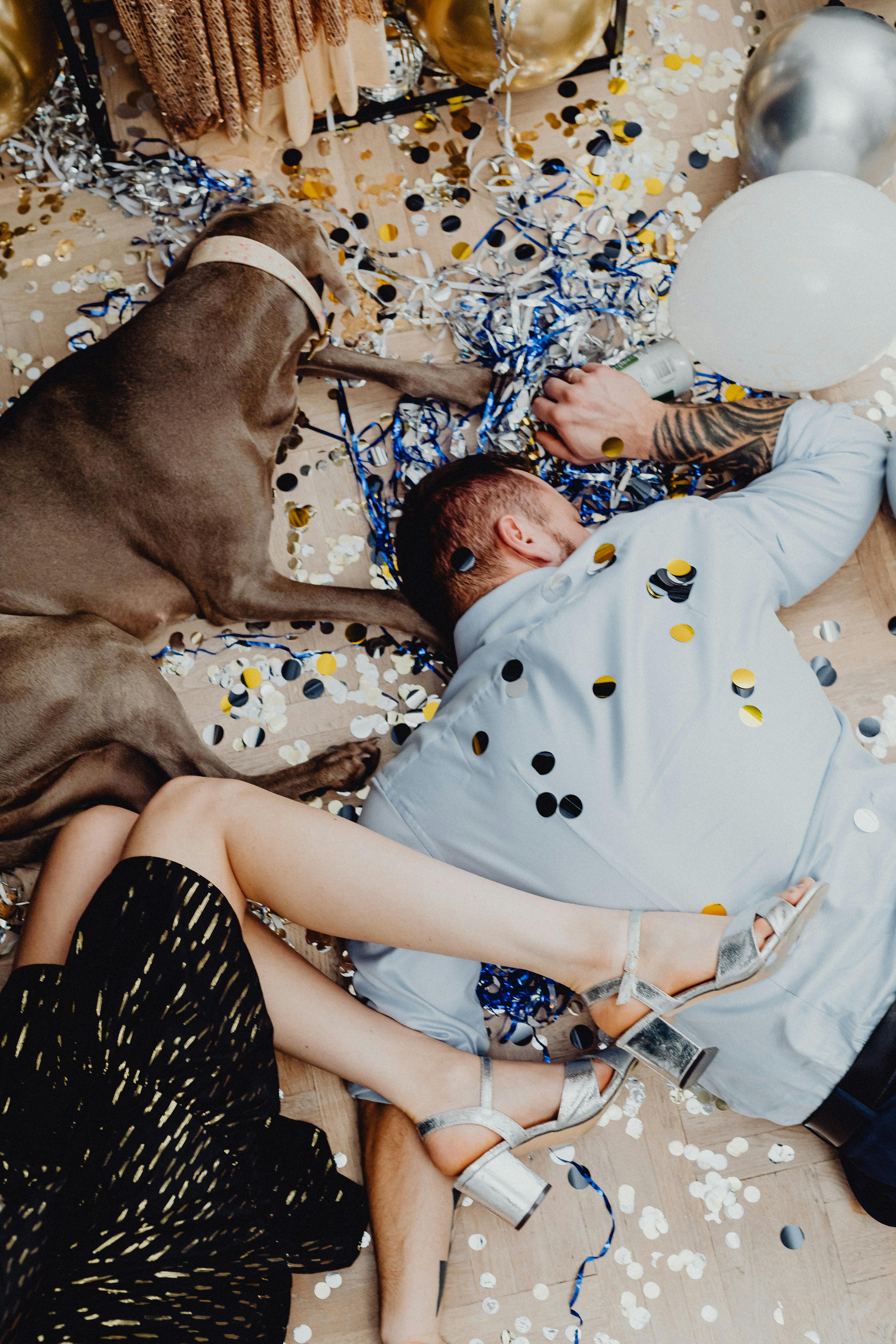 drunk couple lying down the floor with a dog