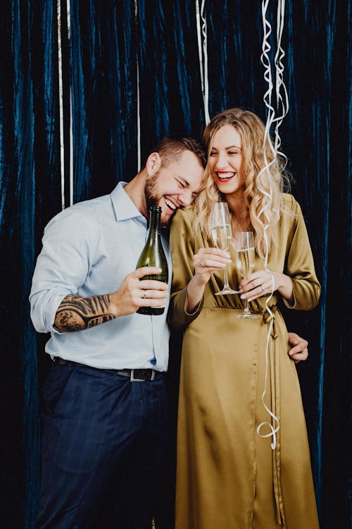 Man and Woman Standing Together Near Dark Blue Curtain