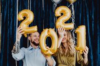 幸福的夫妇在室内举着金气球迎接新年
