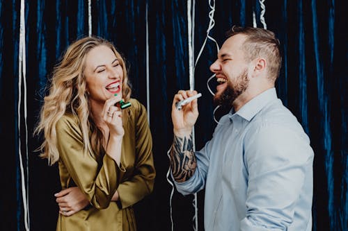 Couple Laughing while Holding Party Horns