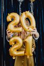 一对幸福的夫妇在室内举着2021年金色气球庆祝新年