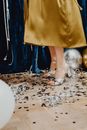 Woman in Yellow Skirt and White Leather Peep Toe Sandals Standing on White and Brown Floral