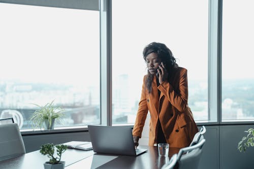 Woman in Brown Blazer Talking on the Phone