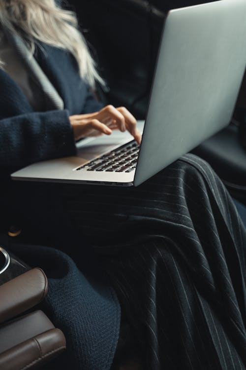Free Person in Blue Coat Using Laptop Stock Photo