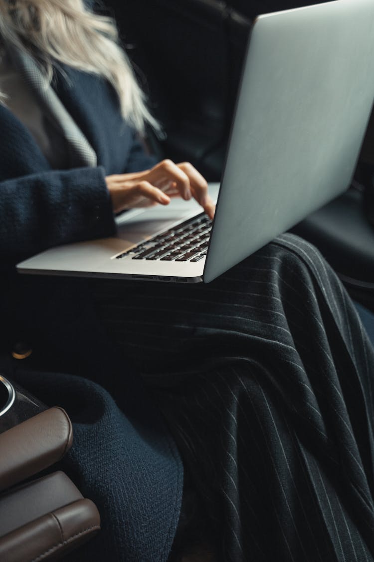 Person In Blue Coat Using Laptop