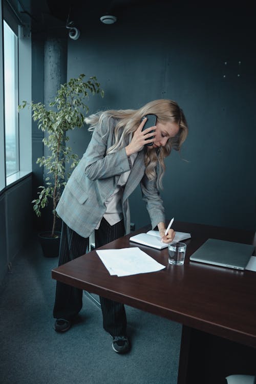 Woman in Gray Blazer Writing on Notebook