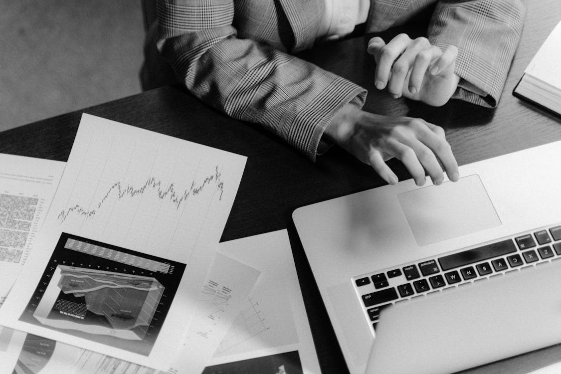 Grayscale Photo of Person Using Macbook