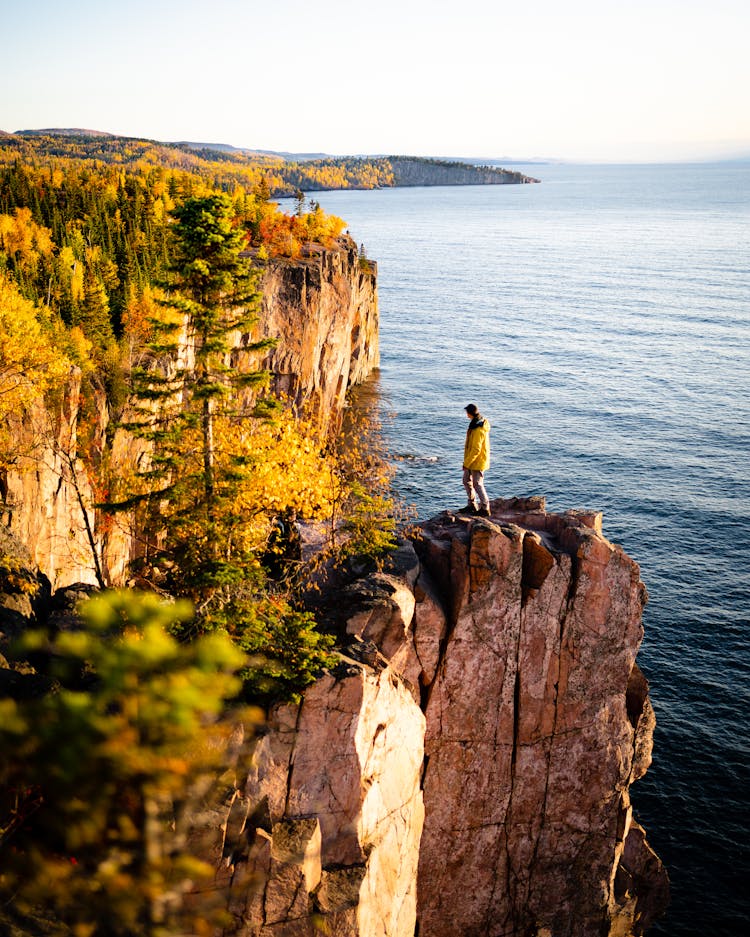 Person On Rocky Cliff In Autumn Sunlight