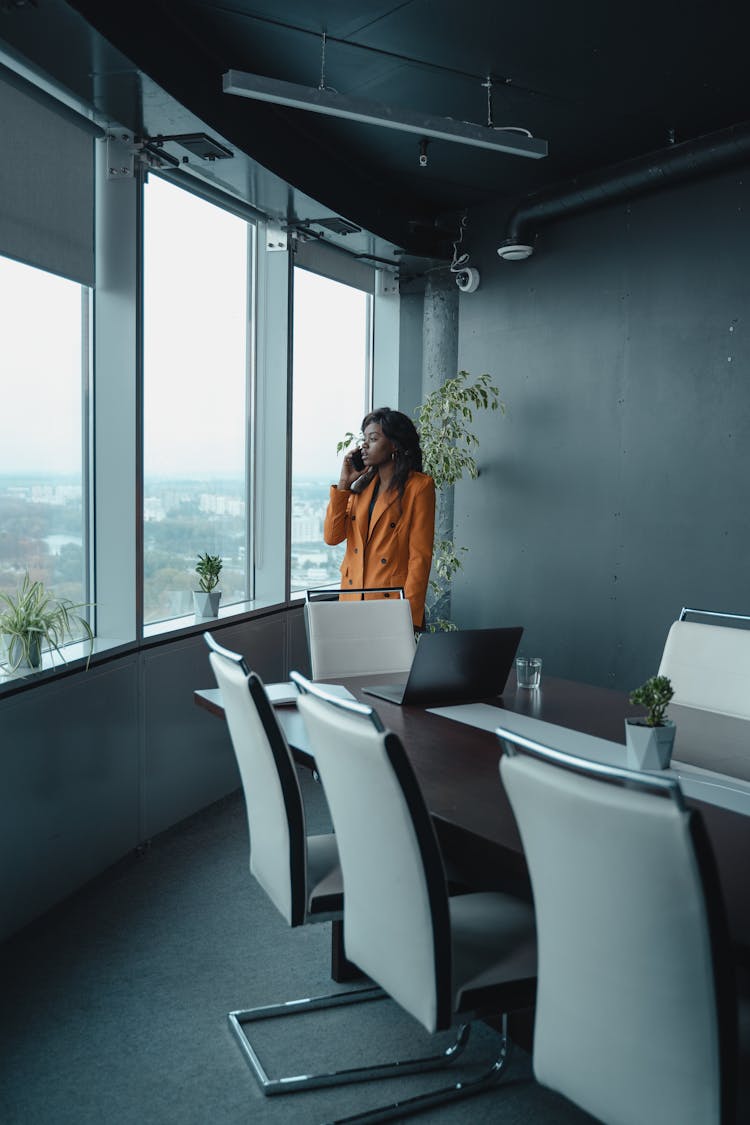 Woman In The Office Talking To Someone  Through Smartphone 