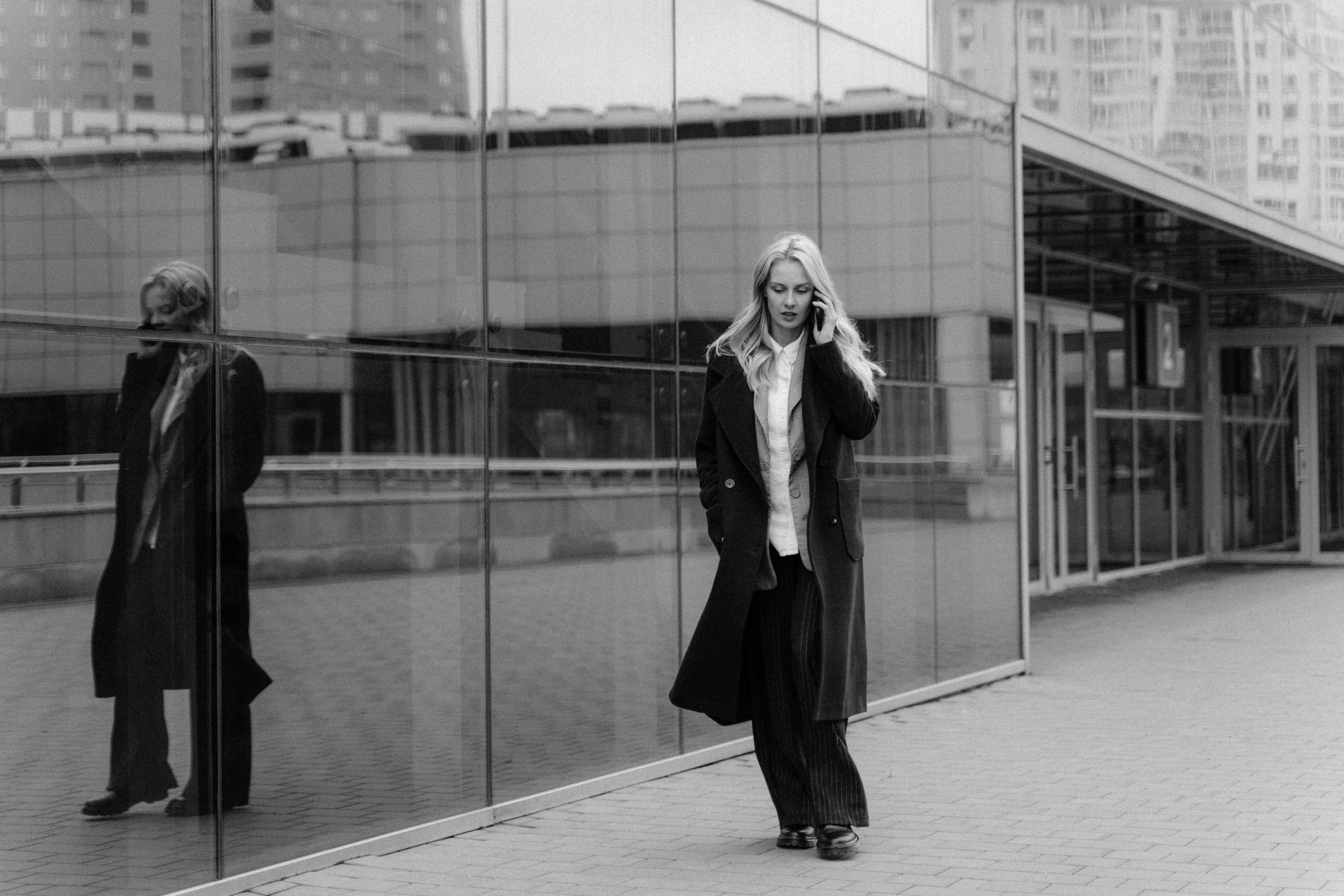 a woman in a coat talking on the phone