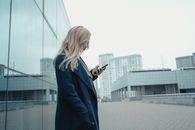 Woman in Blue Long Sleeve Dress Holding Smartphone