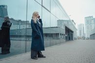 Woman in Blue Coat Standing on Gray Concrete Floor