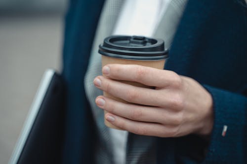 A Person Holding Black and Brown Coffee Cup