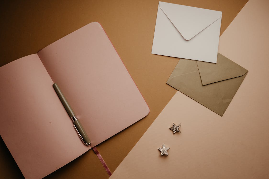 White and Brown Envelopes Near the Notebook · Free Stock Photo