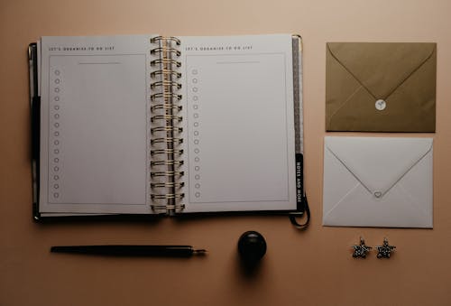 棕色的木桌上的白色螺旋筆記本
