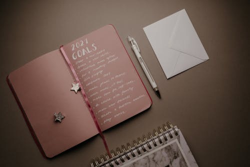 Pink Notebook Beside White Click Pen