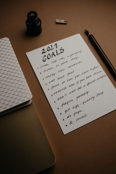 这幅2021年目标清单的艺术静物，配有水墨笔和笔记本，非常适合激发灵感