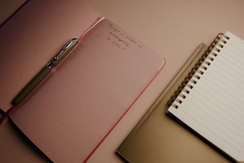 Pink Notebook With Pen on the Table